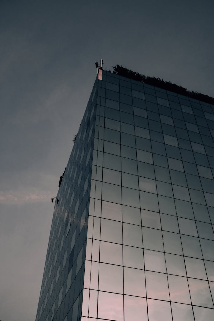 The Art of Drawing Readers In: Your attractive post title goes here Skyscraper with glass facade reflecting the evening sky, showcasing modern urban architecture.